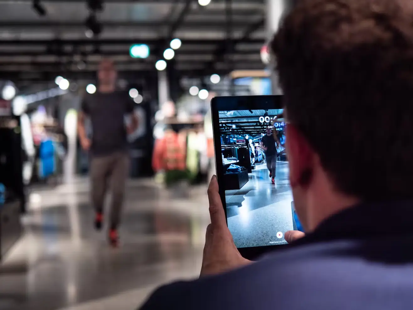 Bild Ein Mann nimmt mit der Arion-App auf einem Tablet einen Läufer auf.