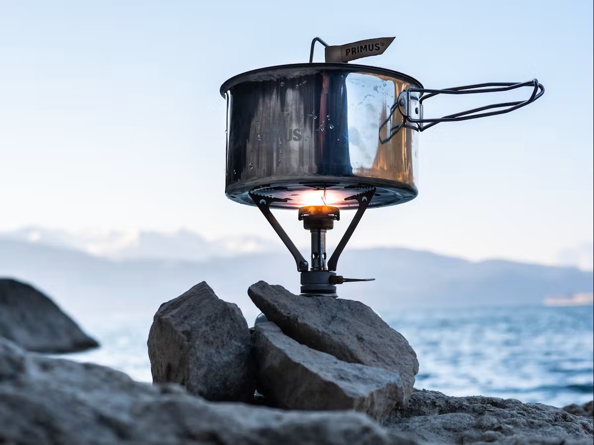 Bild Campingkocher stehend auf einem Stein am Wasser