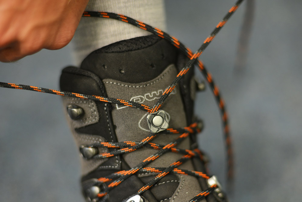 Bild Ein Bergschuh, bei dem man sieht, wie der Zungenhaken geschnuert wird