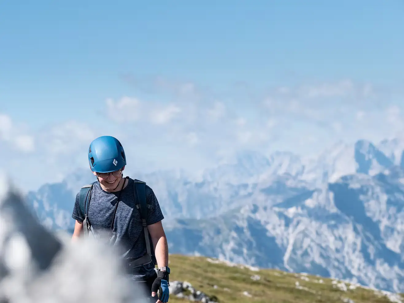 Bild Bergsteiger am Gipfel vor beeindruckendem Bergpanorama