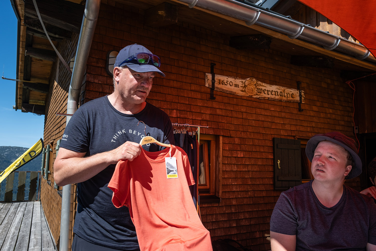 Bild Ein Mann hält ein Shirt in der Hand und erzählt etwas dazu.