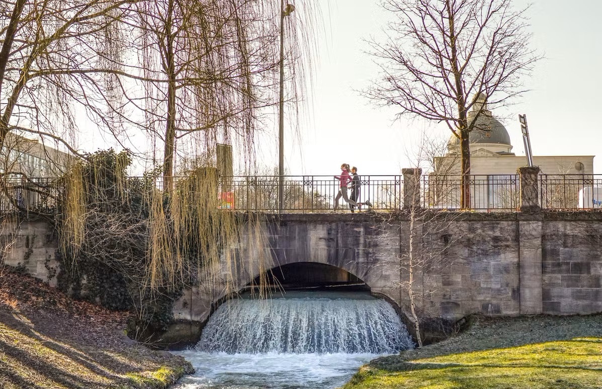 Zwei Läufer*innen auf einer Brücke im Frühling