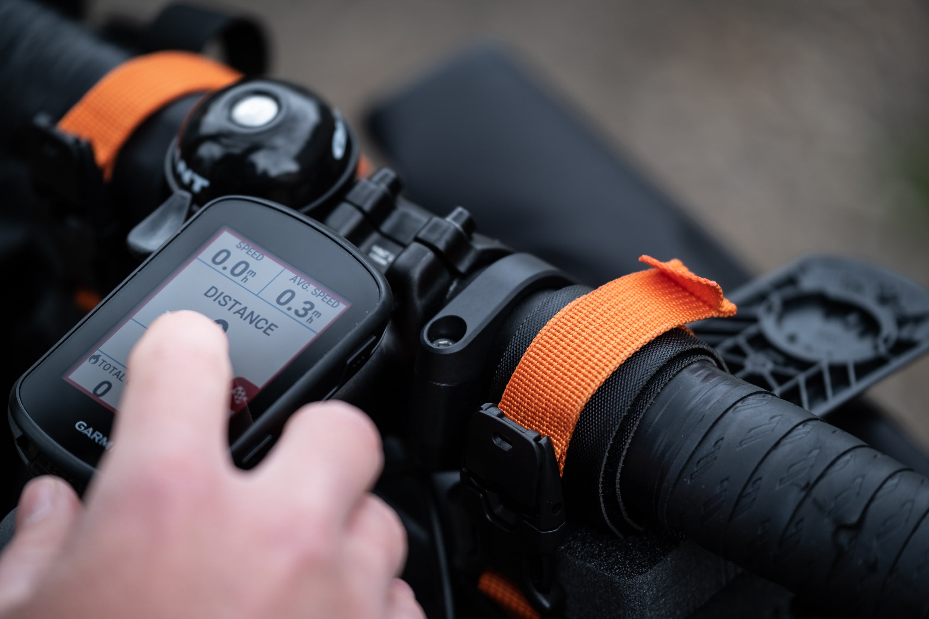 Bild Ein montiertes GPS an einer Lenkerhalterung am Fahrrad, wird von einer Person eingestellt. 