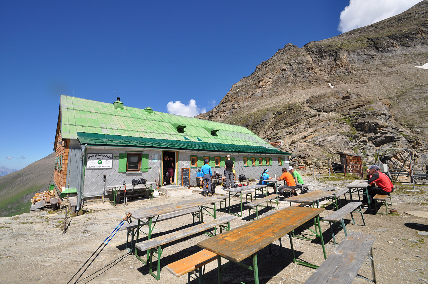 Bild Aufnahme der Heinrich-Schwaiger-Hauses in der Sonne auf einem felsigen Plateau.