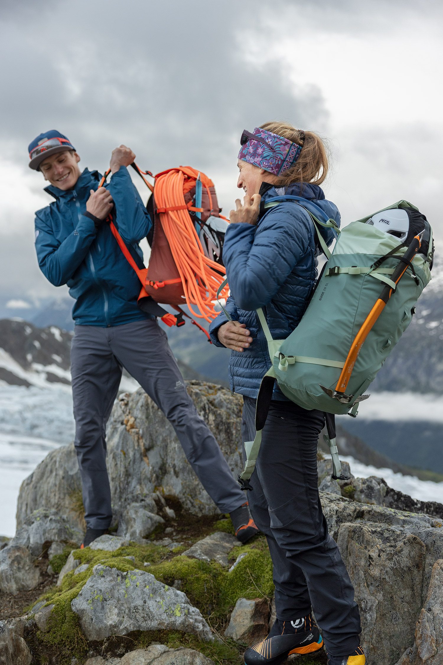 Bild Zwei Bergsteiger in alpiner Umgebung ziehen ihre Rucksäcke auf