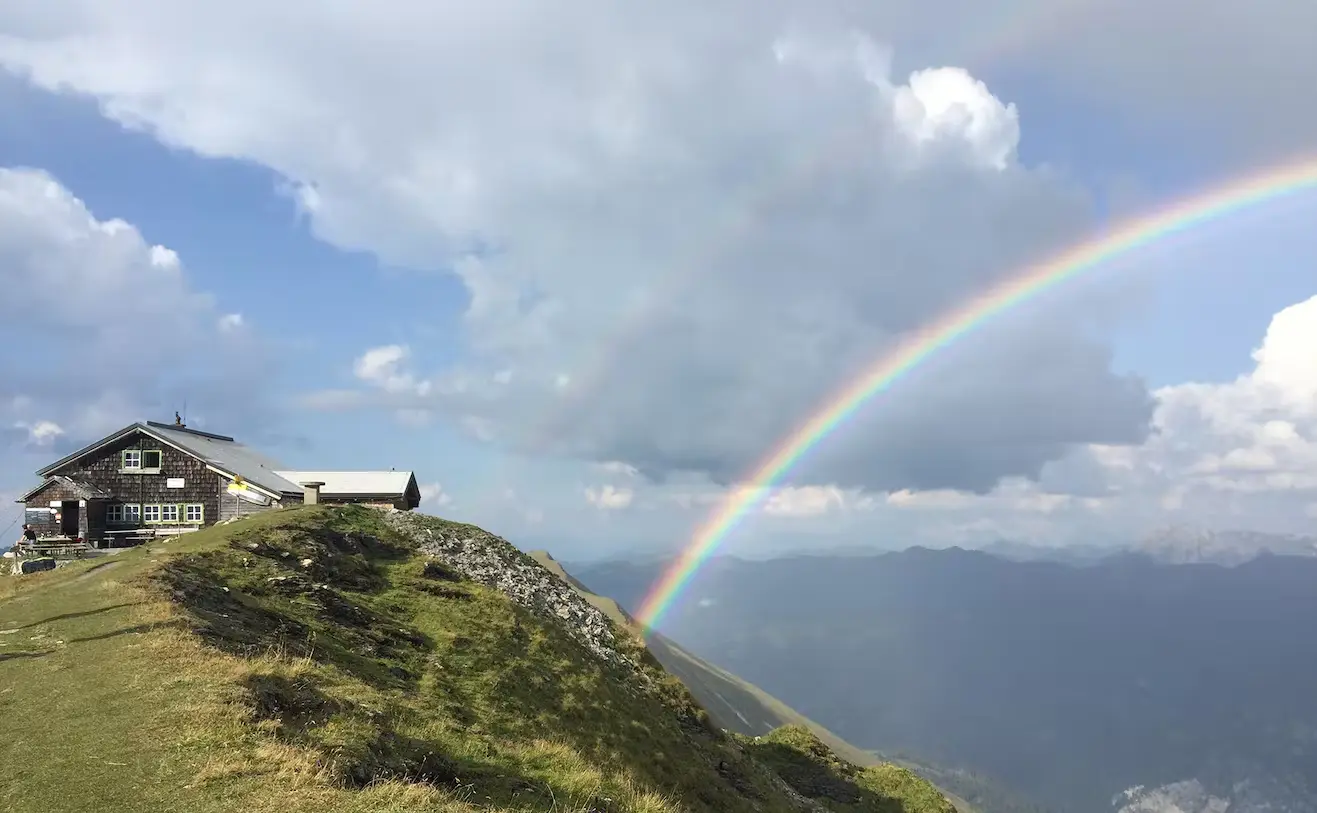 Bild Ein Regenbogen hinter einer Berghütte