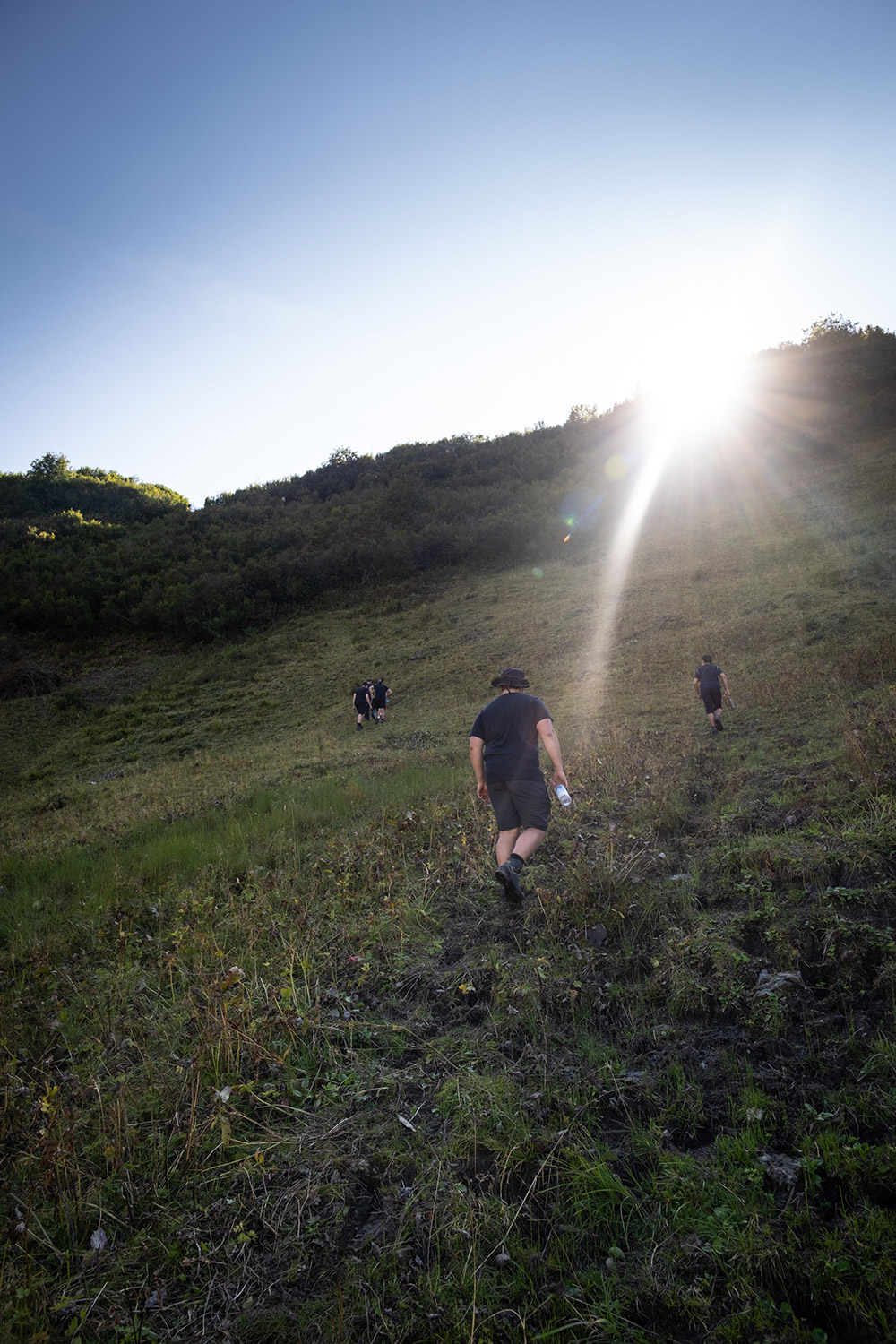 Bild Wanderer im Gegenlicht an einem steilen Berghang