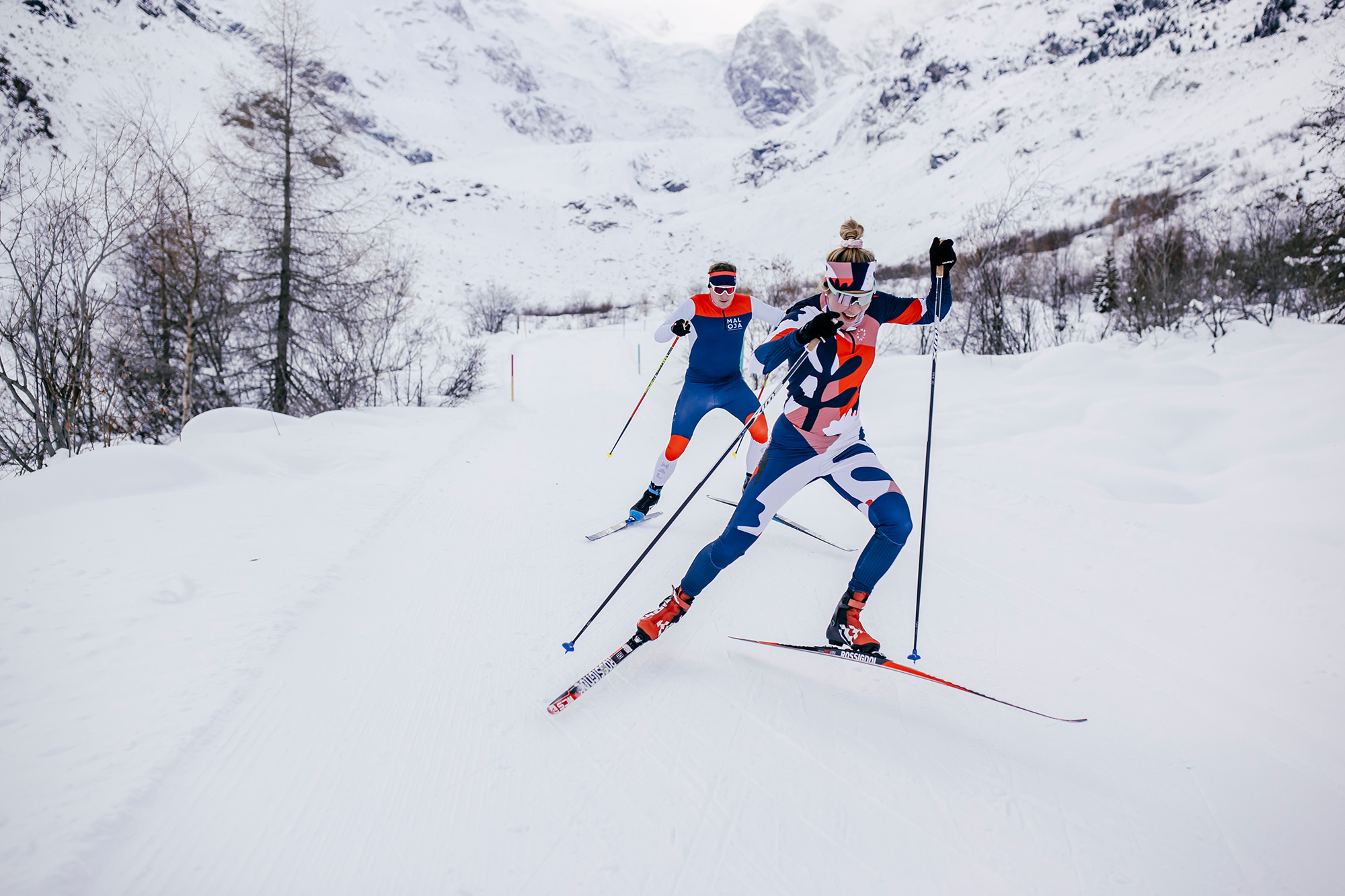 Zwei Langläufer*innen im Skating-Stil auf der Loipe