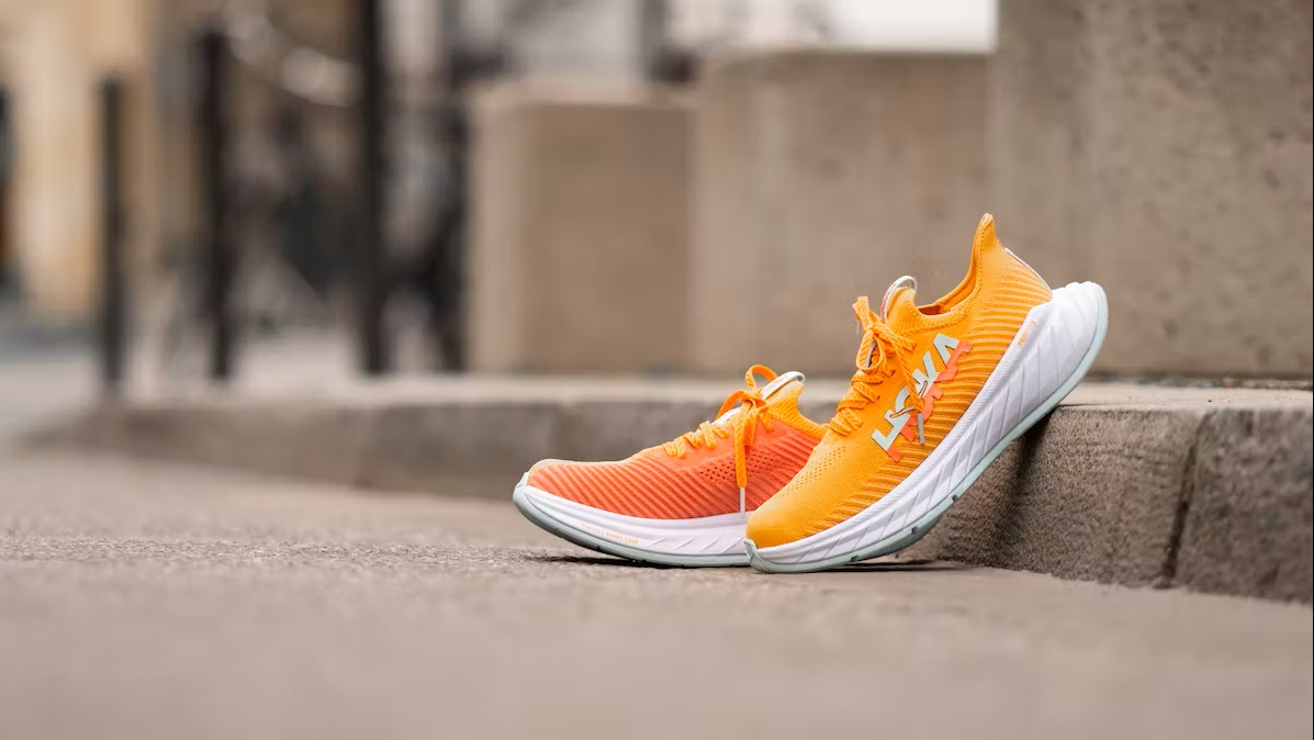 Bild Ein Paar Orange Hoka Laufschuhe am Bürgersteig 
