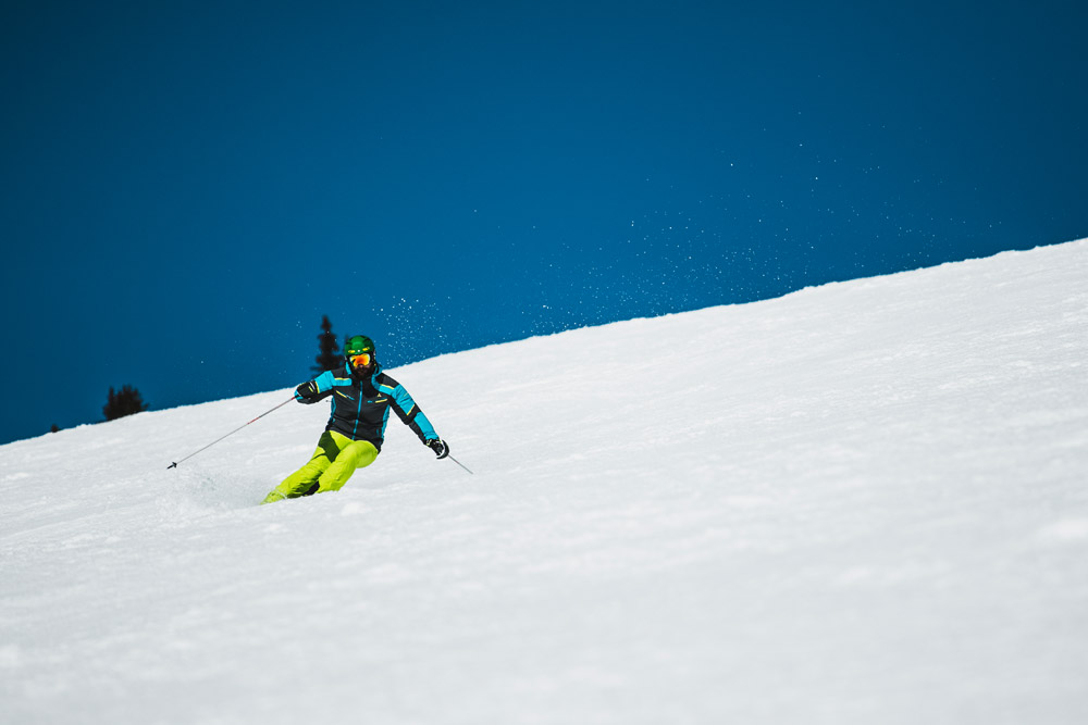 Bild Skifahrer auf sonniger Piste bei der Abfahrt