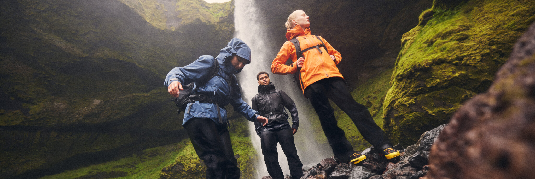 Drei Menschen vor einem Wasserfall in Gore-Tex Bekleidung
