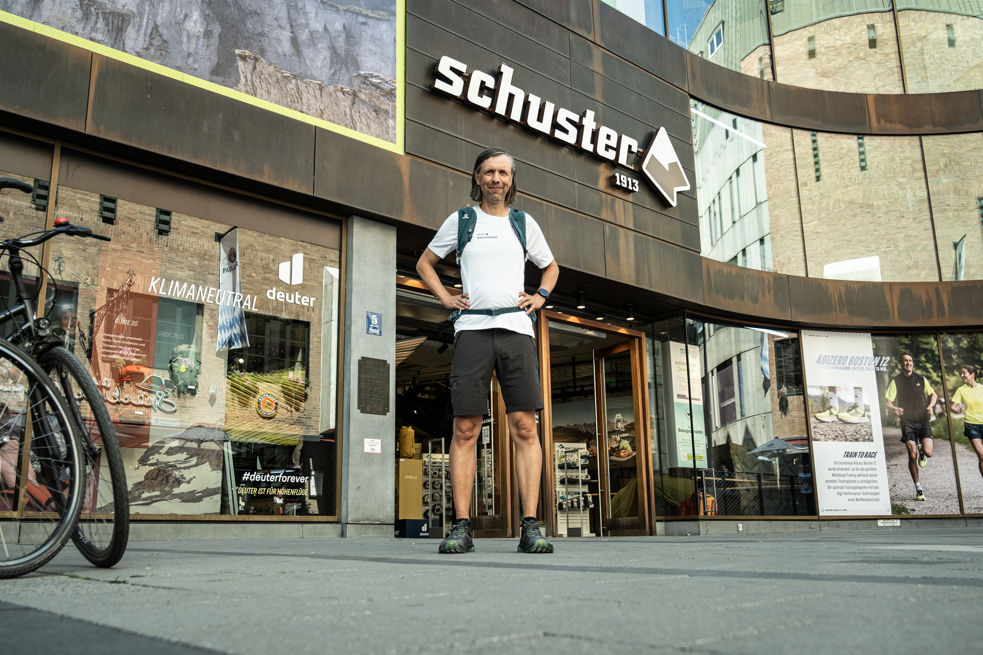 Bild Ein Mann in Sportbekleidung steht vor dem Eingang vom Münchner Sporthaus Schuster