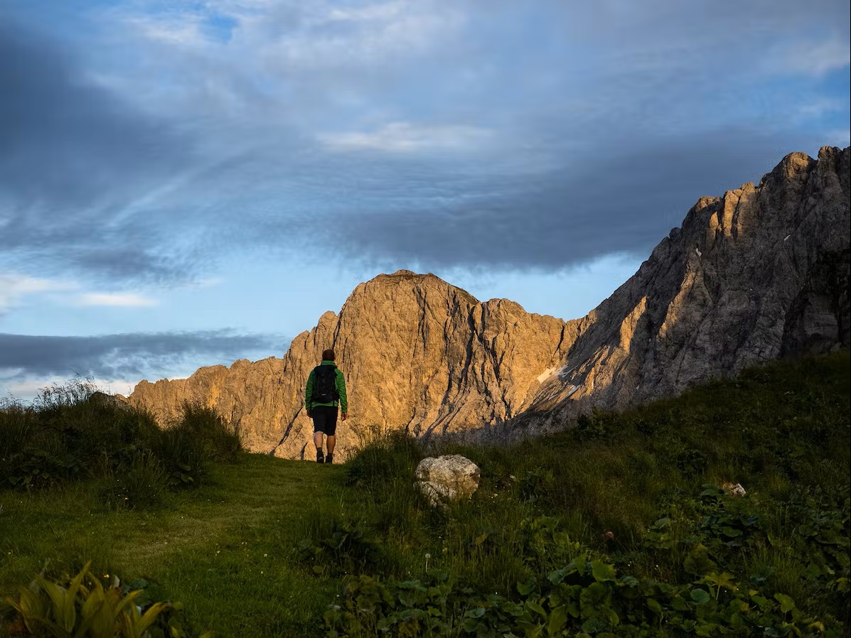 Bild Mann wandert richtung hohe Berge