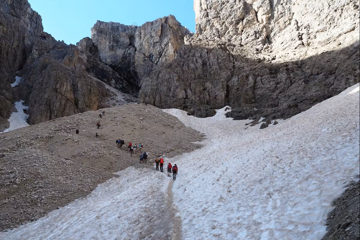 Bild Wandergruppe passiert das Schneefeld am Grödnerjoch