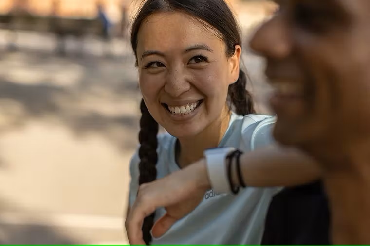 Bild Sportlerin lächelt den Laufpartner an