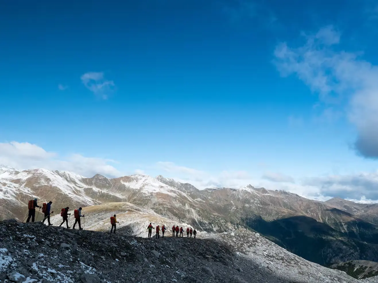 Bild Eine Gruppe Bergsteiger in sonniger, hochalpiner Berglandschaft.
