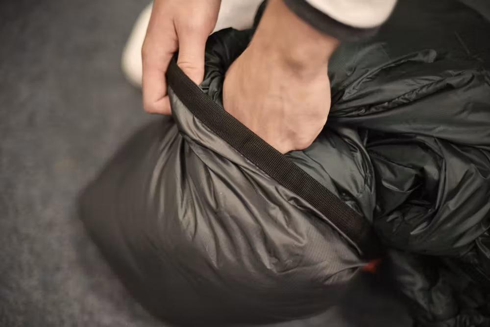 Bild Person packt einen Schlafsack ein