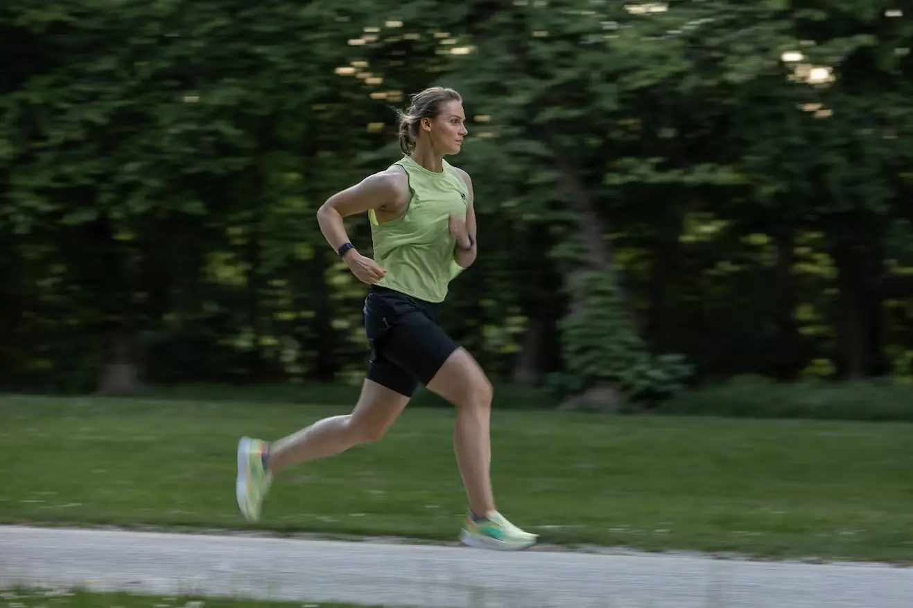Bild Joggerin im schnellen Lauf in grün bewachsener Umgebung