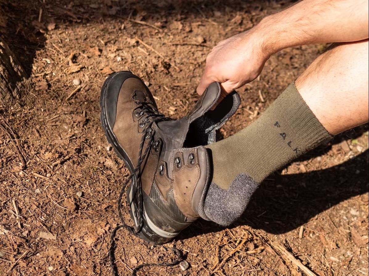 Bild Wanderer mit Falke Wandersocken sieht seinen Wanderschuh an