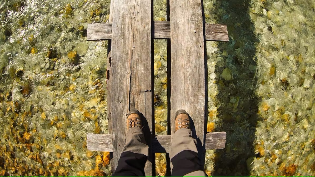 Bild Wanderer mit Bergschuhen an steht am Steg