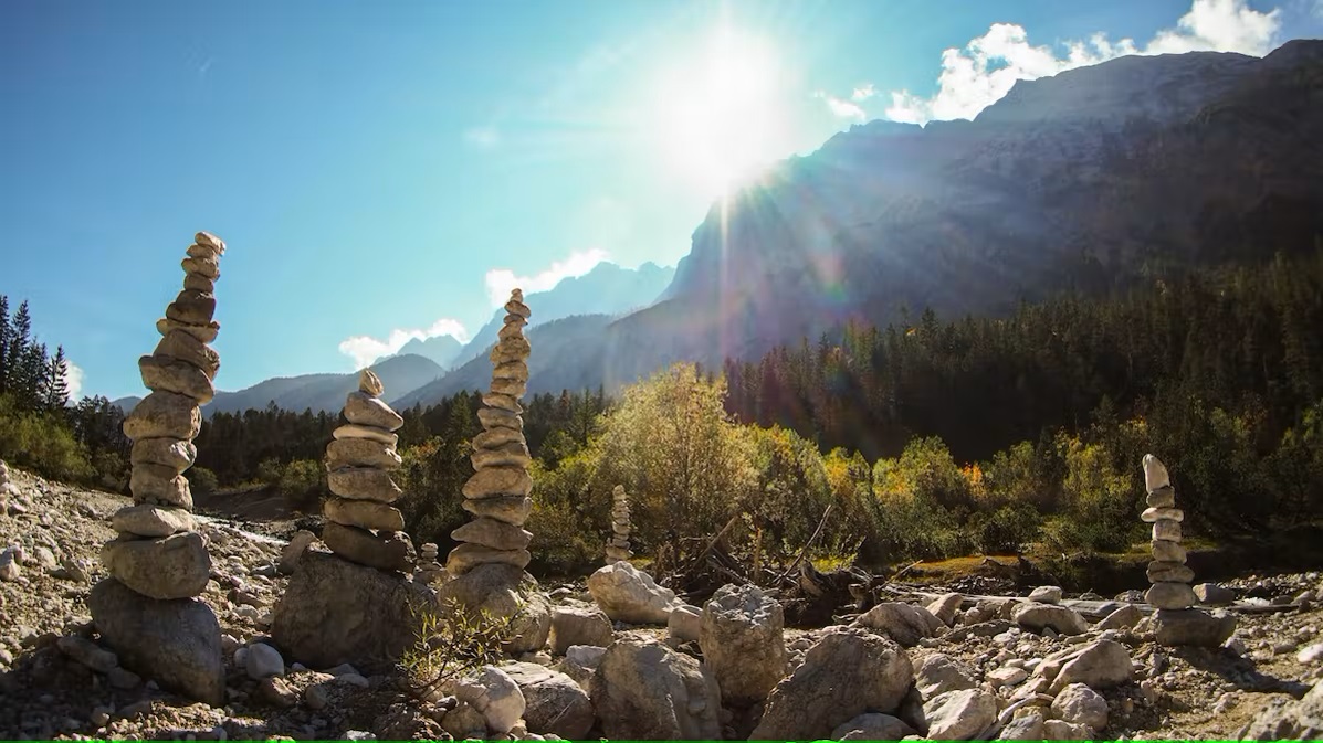 Bild Pfadfinder aus Stein bei Sonnenschein in den Bergen