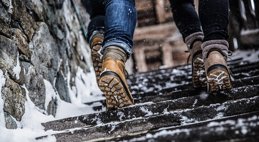 Zwei Leute mit Winterschuhen auf einer Treppe