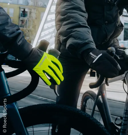 Zwei Fahrradfahrer*innen mit Handschuhen