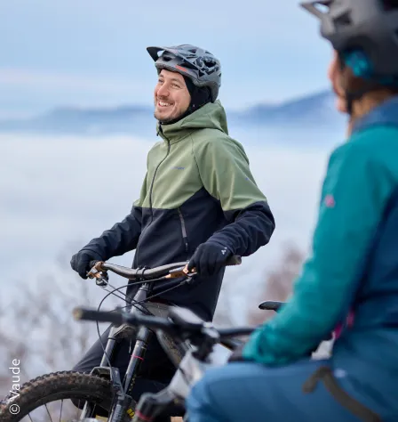 Zwei Mountainbiker vor winterlicher Landschaft