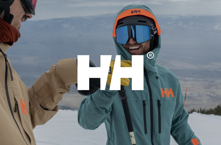 Zwei Skifahrer*innen und Helly Hansen Logo