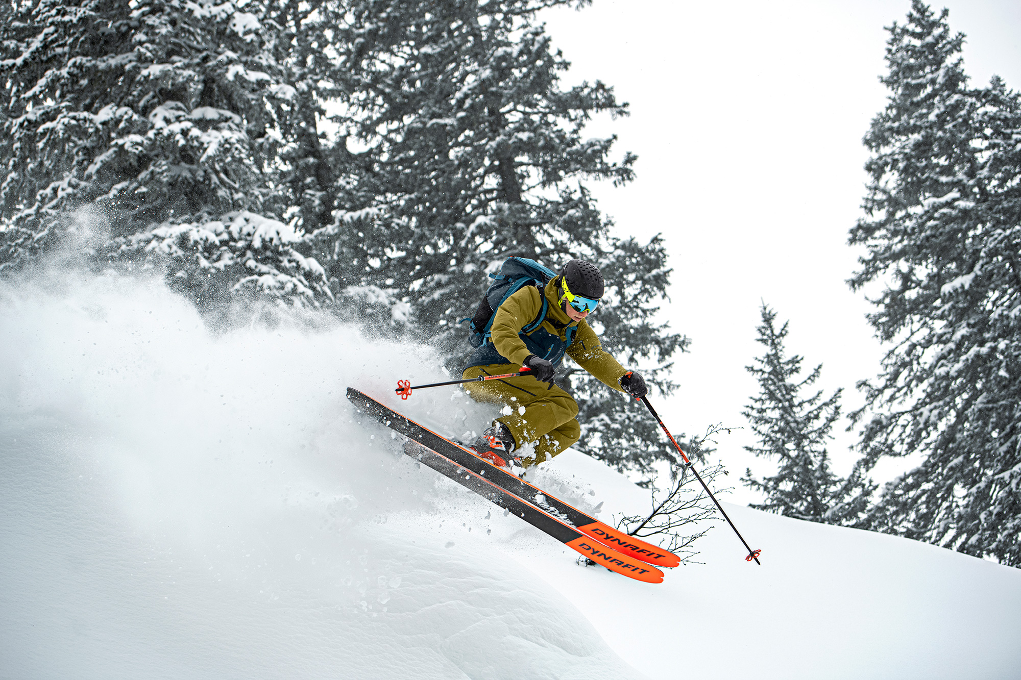 Bild Ein Skifahrer bei der Abfahrt im Pulverschnee waehrend eines kleinen Sprungs