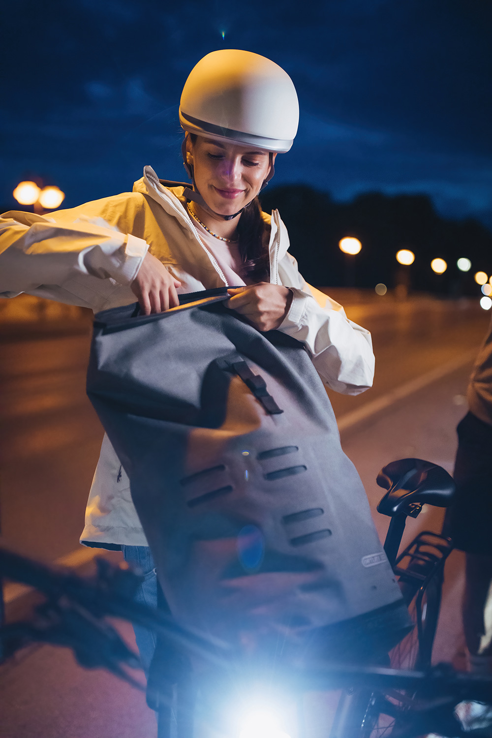 Bild Frau, nachts mit einem grauen Fahrradrucksack.