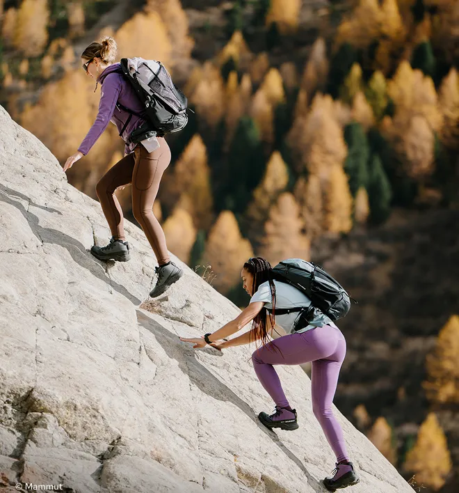 Zwei Frauen mit Wanderrucksäcken am Berg
