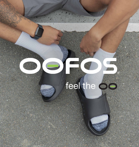 Person mit oofos Schuhen und oofos Logo