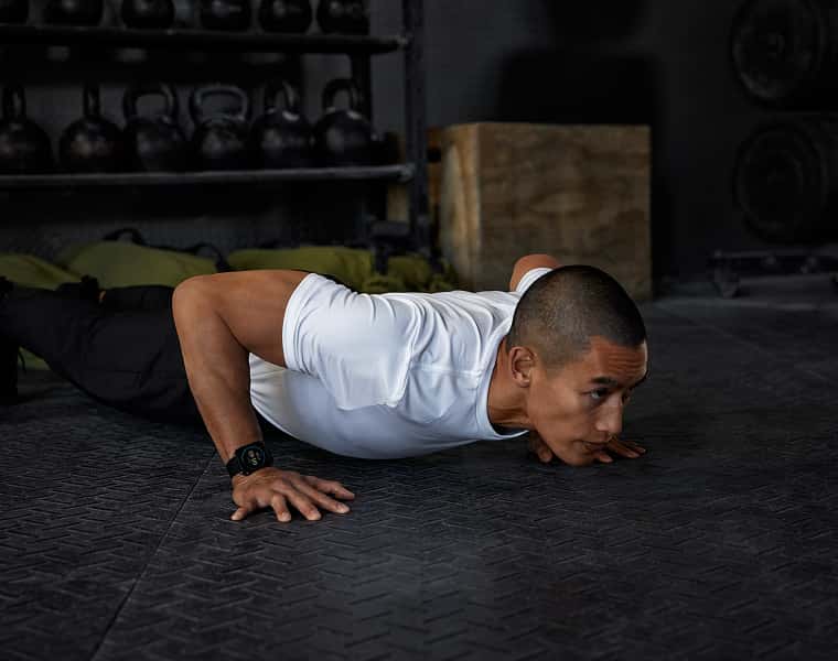 Mann mit Garmin Uhr am Handgelenk macht Liegestütze