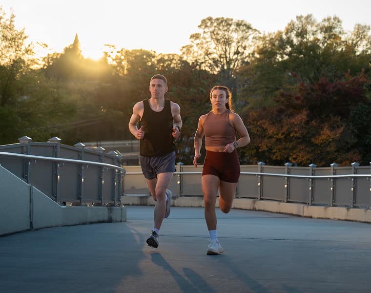 Zwei Läufer*innen auf einer Laufbahn