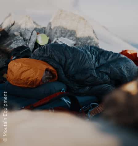 Person in Schlafsack im Schnee