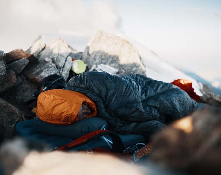 Schlafende Person in einem Daunenschlafsack