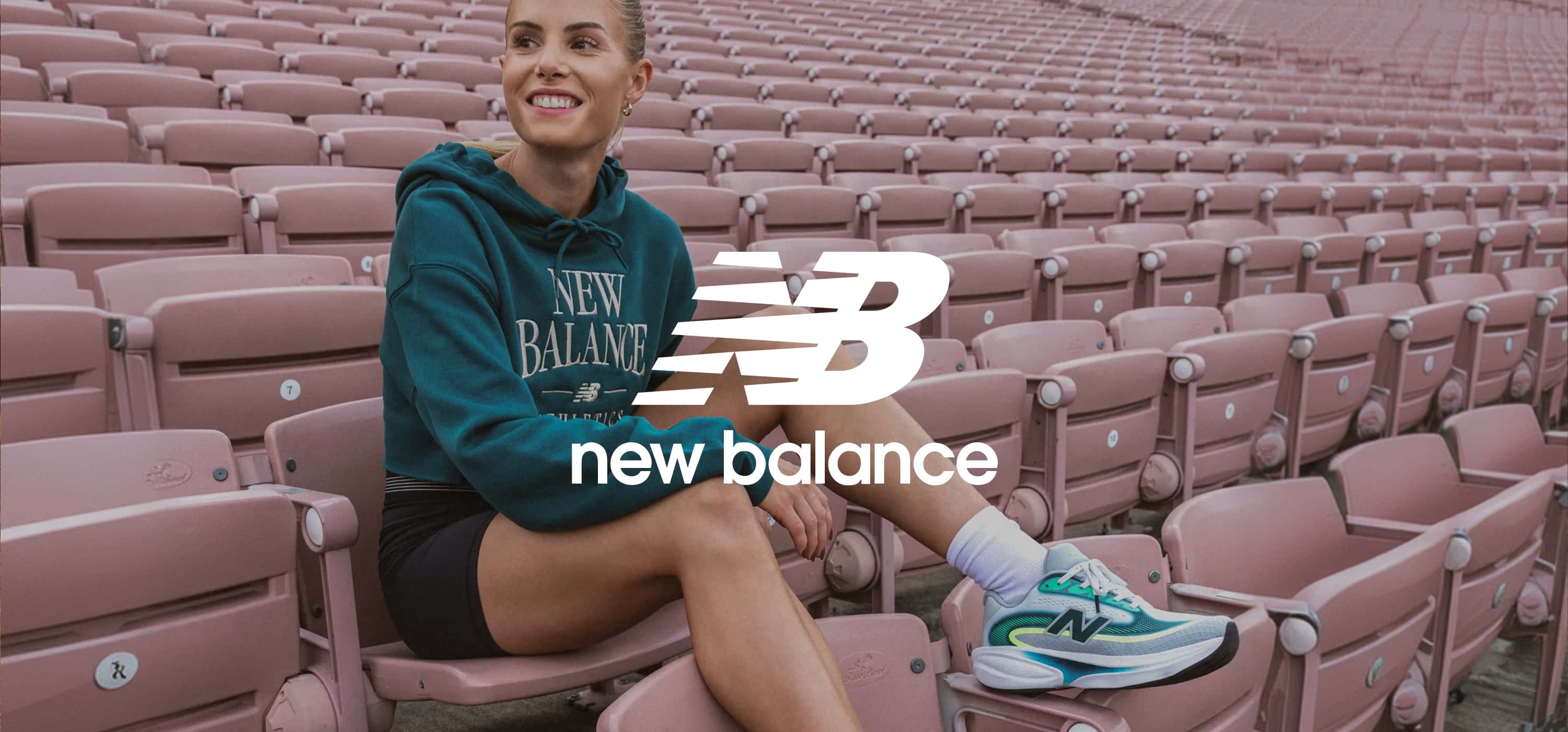 Frau in einem Stadion und New Balance Logo