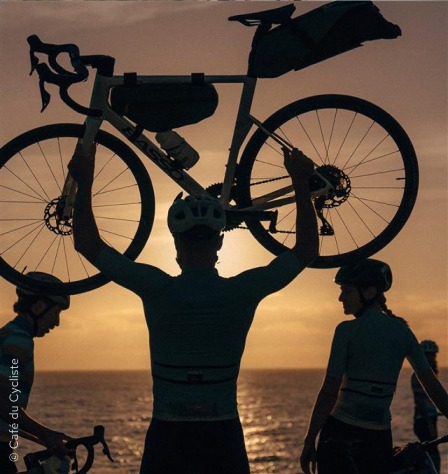 Rennradfahrer hebt Fahrrad hoch