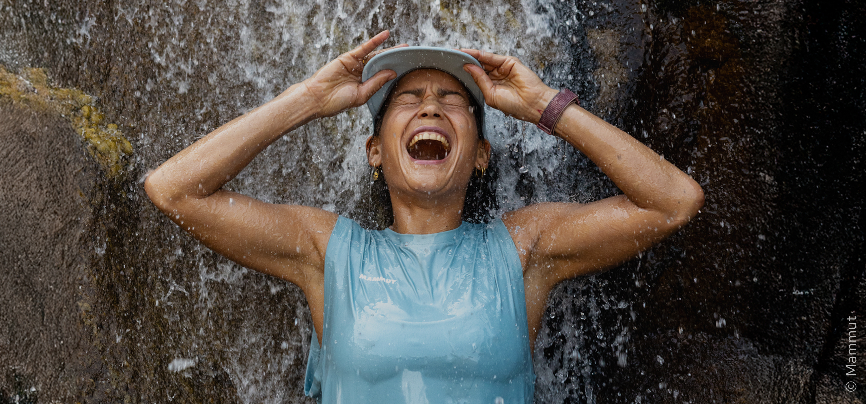 Frau steht unter Wasserfall
