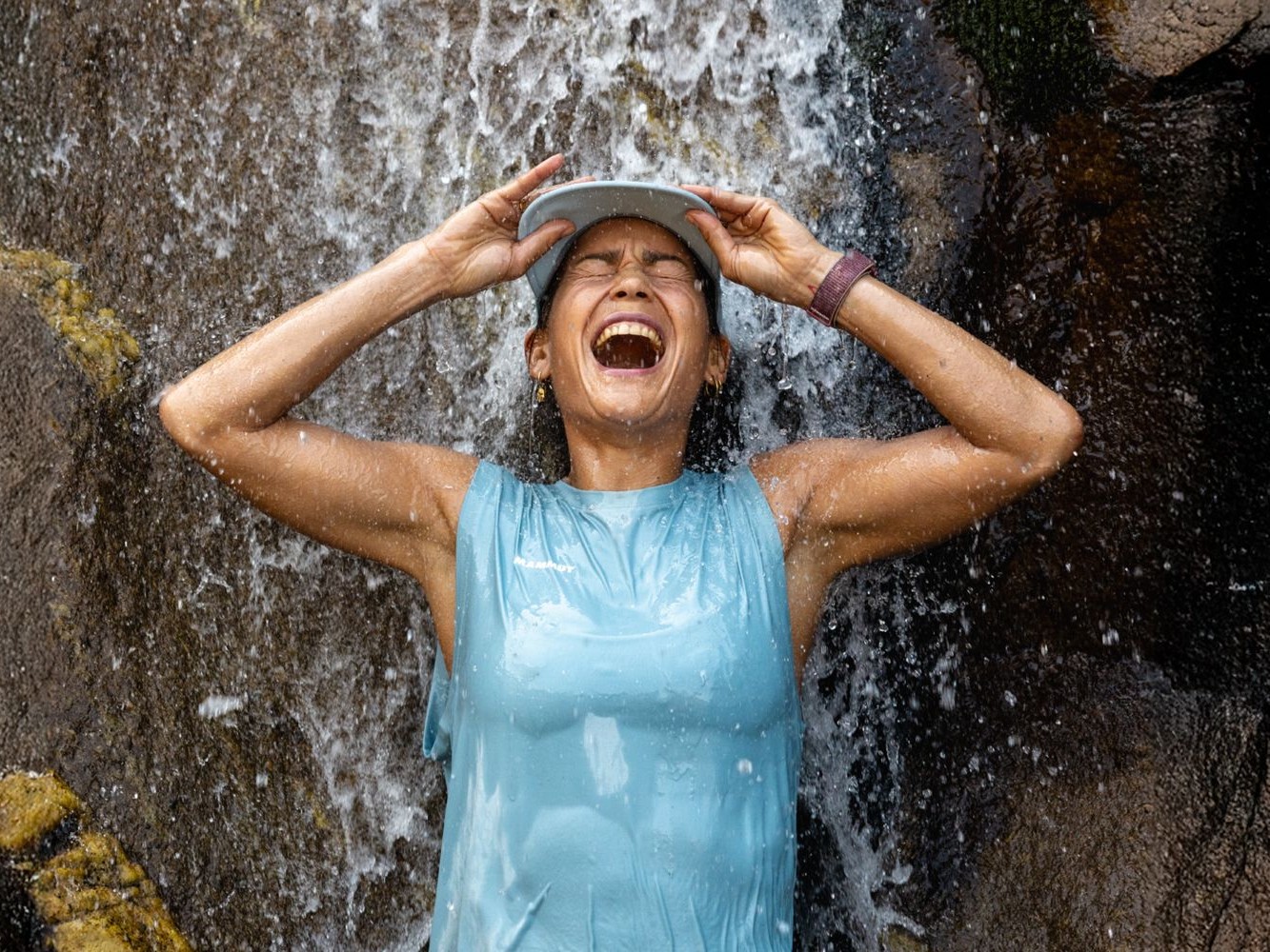 Frau steht unter einem Wasserfall