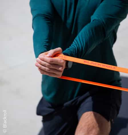 Mann macht Übung mit Fitnessband