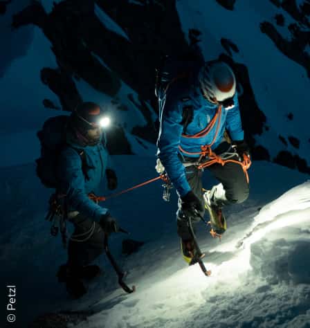 Zwei Personen mit Stirnlampen und Seilen