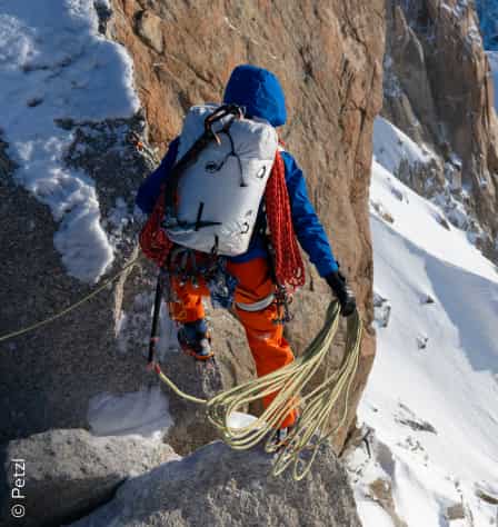 Person mit Kletterseilen am Fels