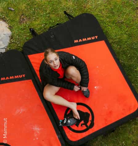 Frau sitzt auf einem Crashpad