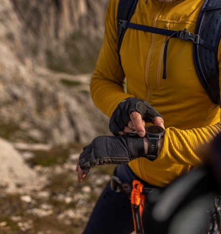 Mann trägt Kletterhandschuhe