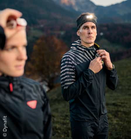 Zwei Läufer mit Jacken und Stirnlampen