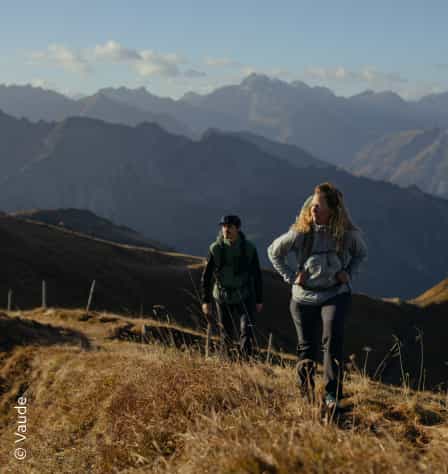 Zwei Wanderer*innen in herbstlicher Bergkulisse
