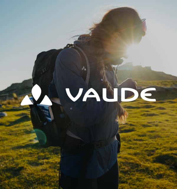 Frau mit Wanderrucksack und Vaude Logo