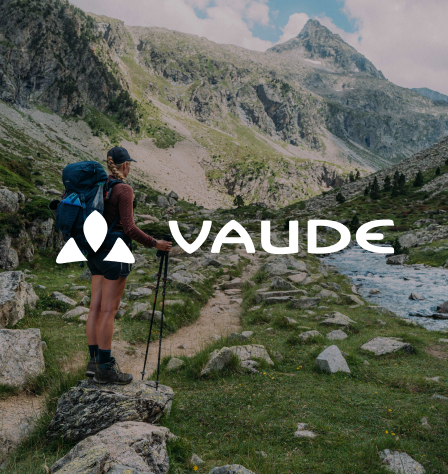 Person in den Bergen und Vaude Logo